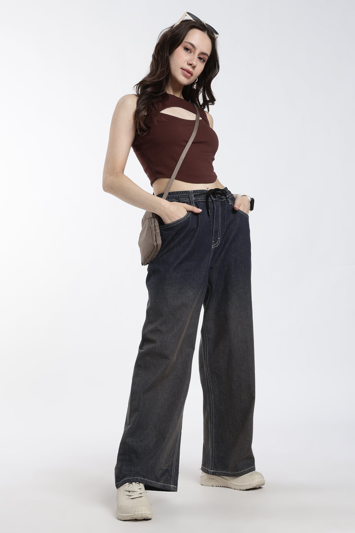 Woman wearing a brown top and vintage wash jogger on a white background