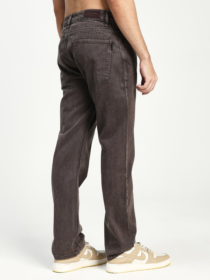 man wearing dark brown ecru jeans on a white background