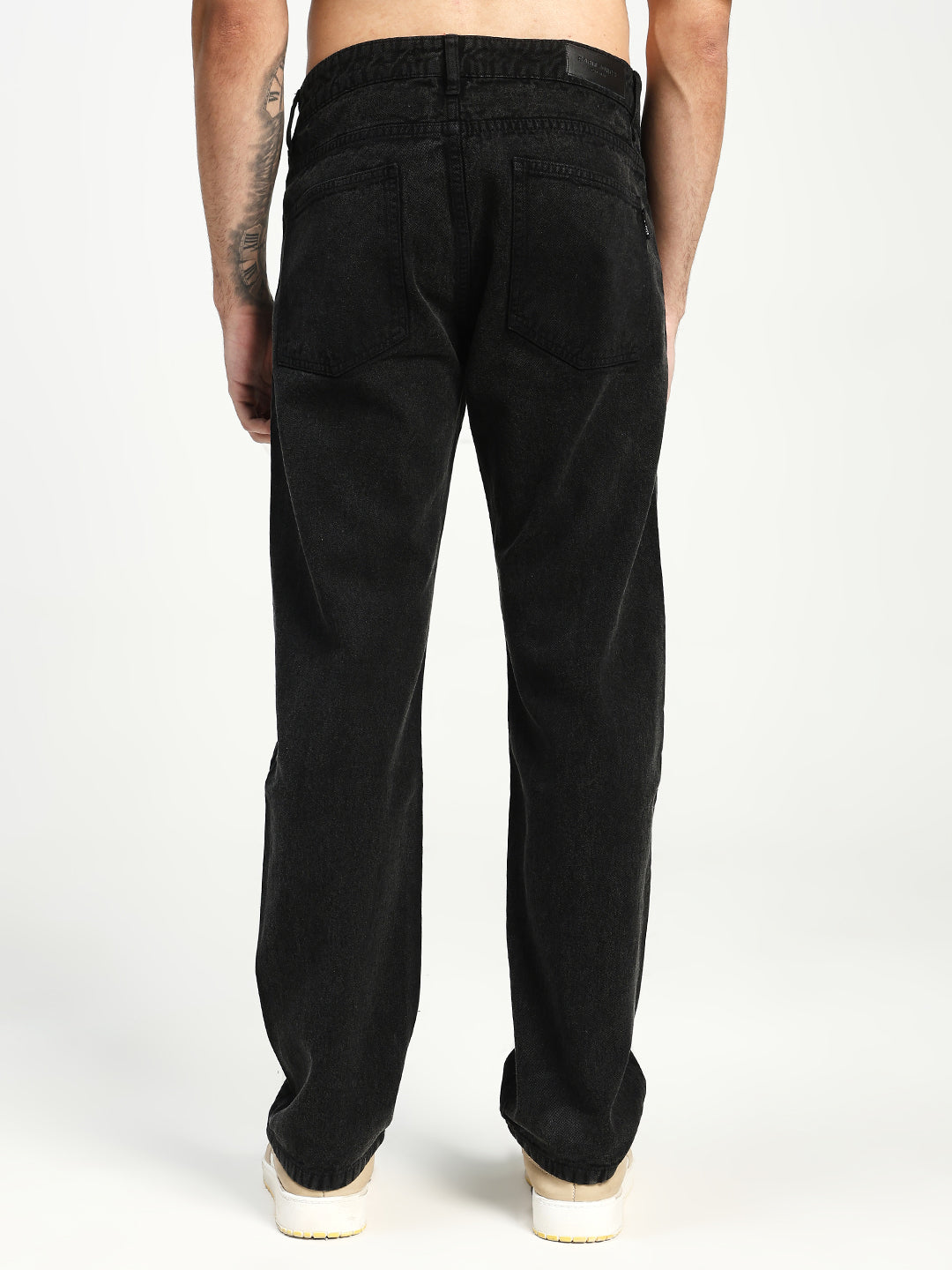 man wearing black ecru jeans on white background 