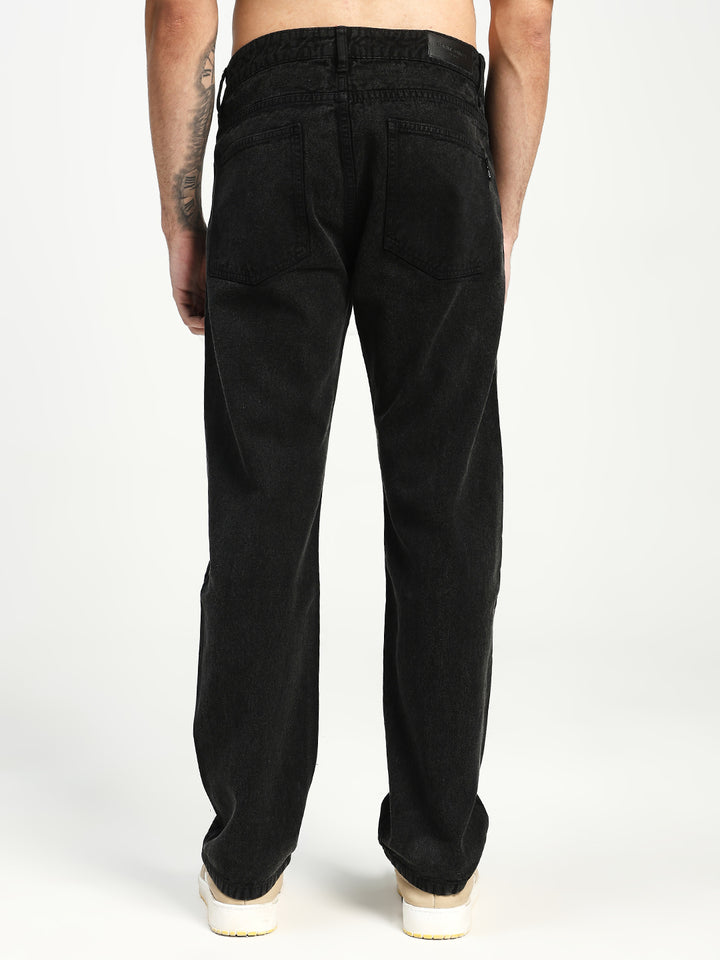 man wearing black ecru jeans on white background 