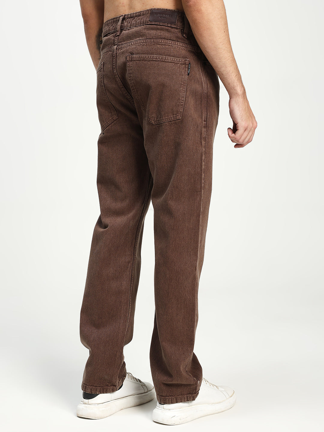 man wearing brown ecru jeans on white background 