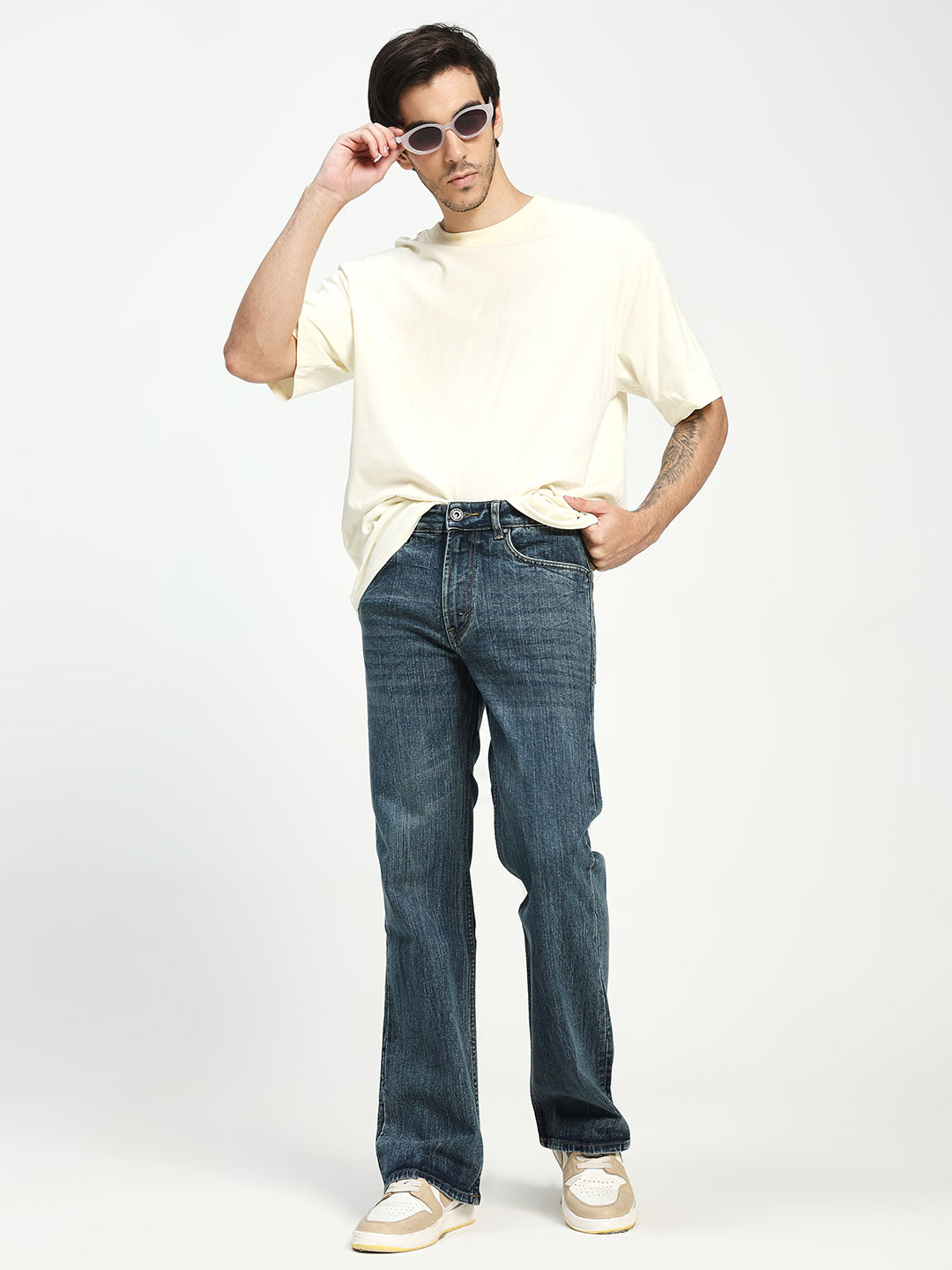 man wearing dark blue bootcut jeans on a white background