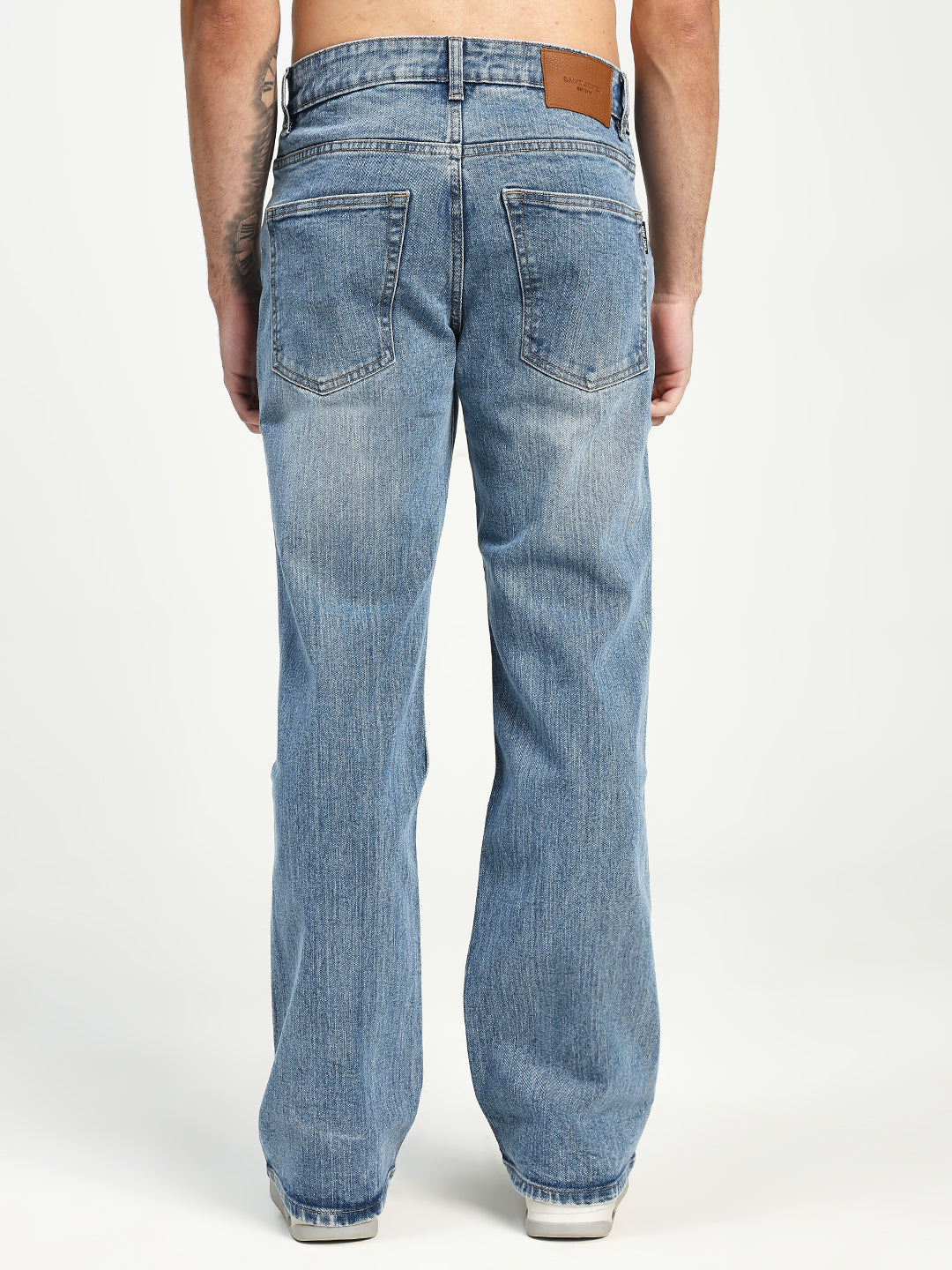 Blue bootcut jeans worn by a man on a white background