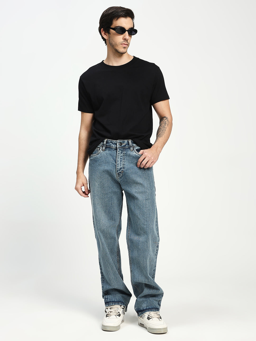 Man wearing a black t-shirt, blue jeans, and sunglasses on a white background