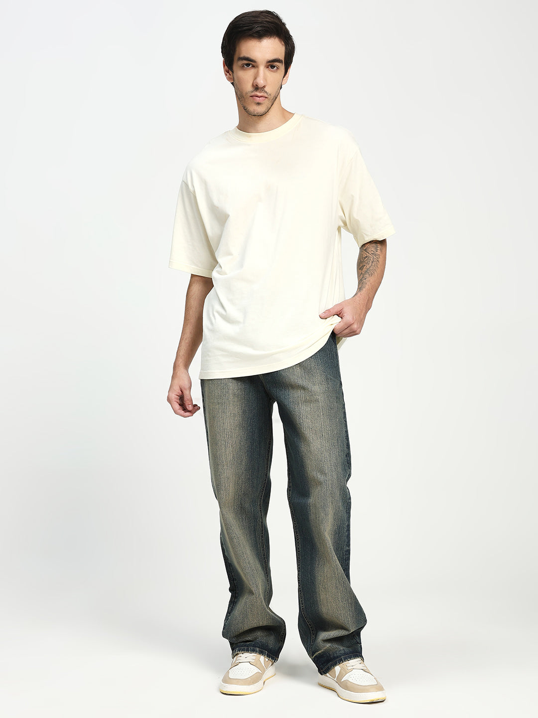 Man wearing a white t-shirt and blue jeans on a white background