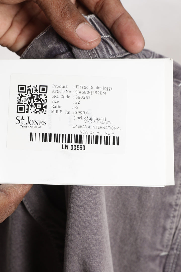 Close-up of a label on gray jogger with a QR code and text.