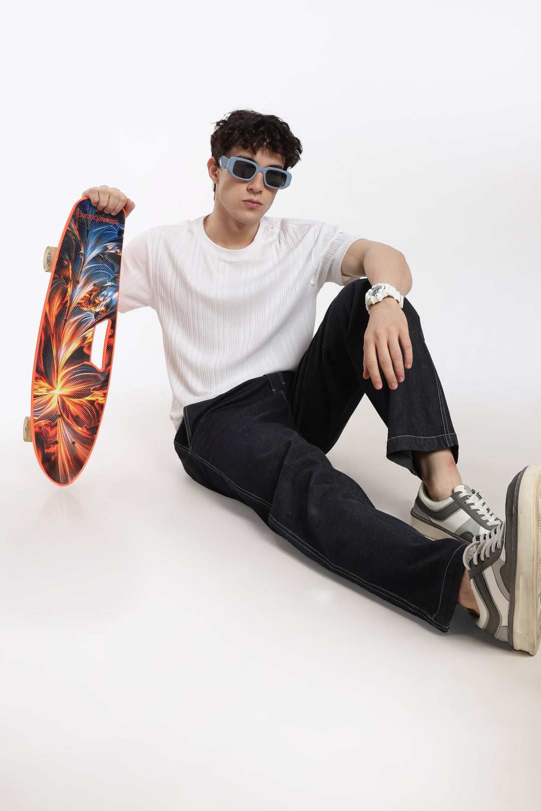 man holding a colorful skateboard against a white background