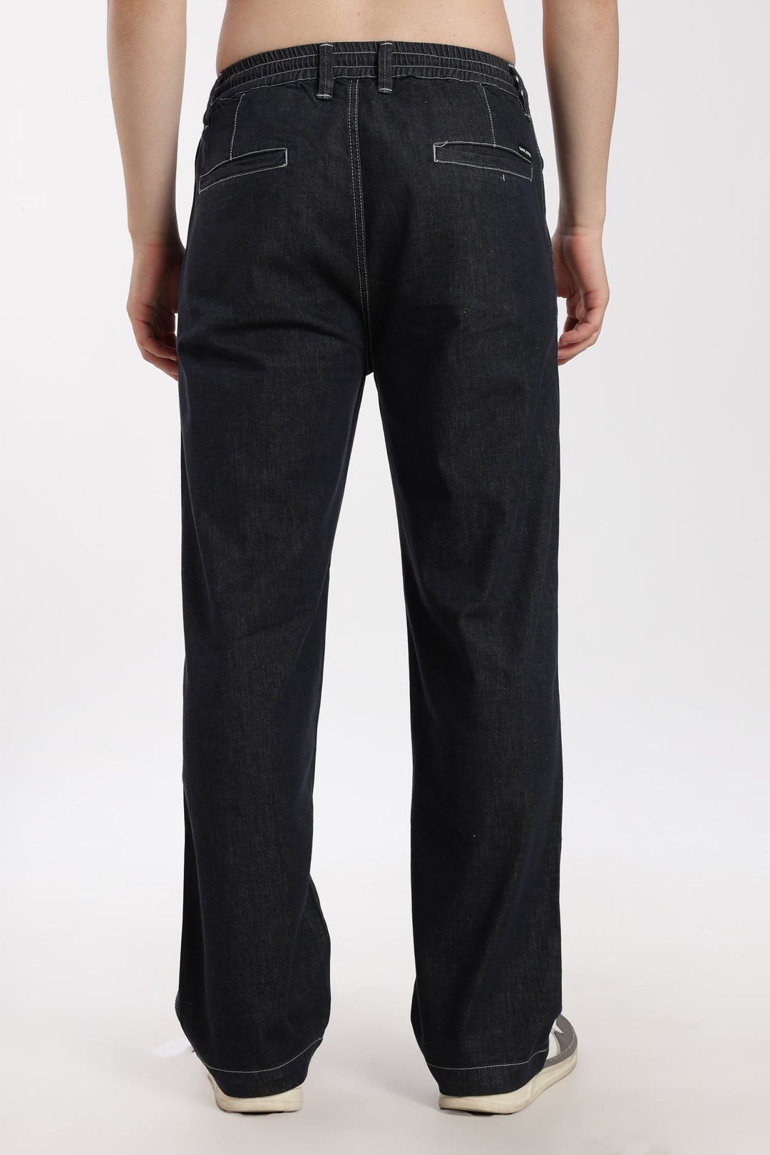 man wearing dark wash denim jogger pant on a white background
