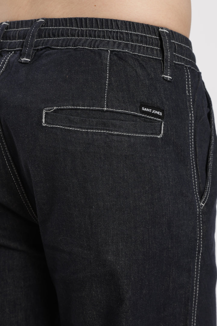 dark wash denim jogger pant with a brand saint jones on the back pocket against a white background