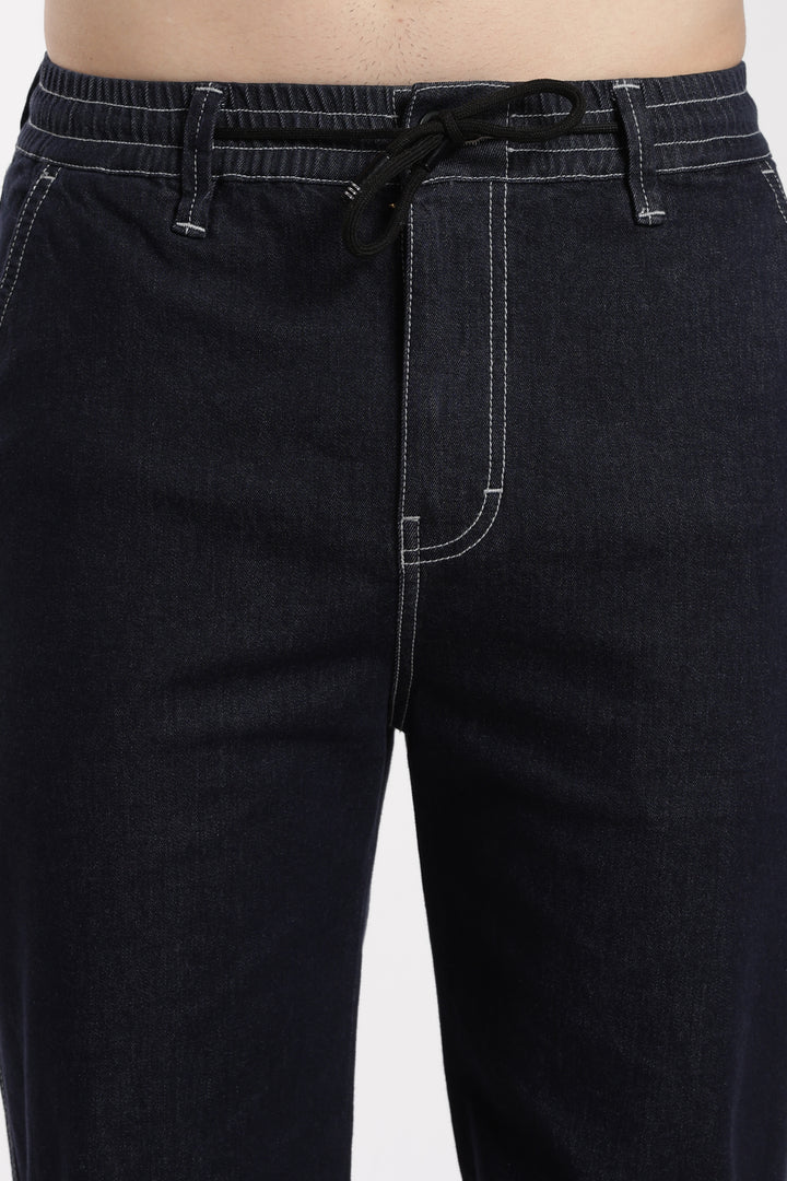 navy blue denim jogger pants with a drawstring waistband on a white background
