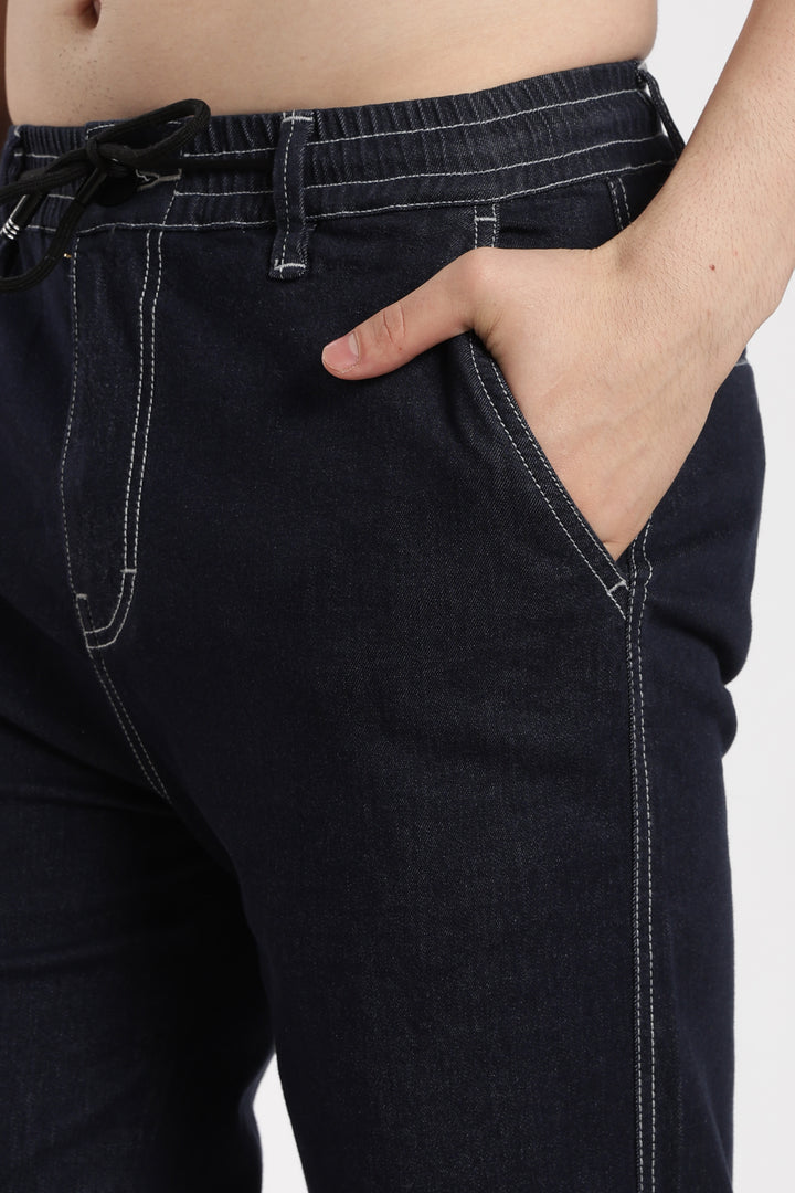 navy blue denim jogger jeans worn by a man on a white background