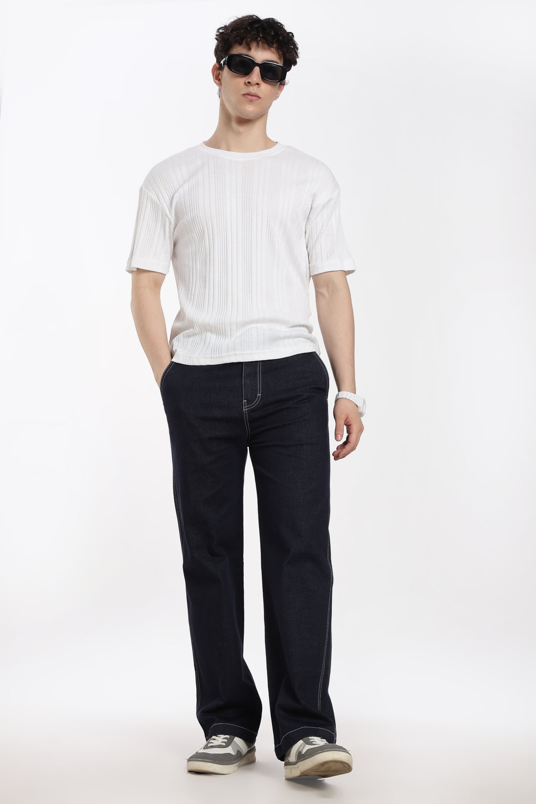 man wearing a white t-shirt and navy blue jogger pants on a white background