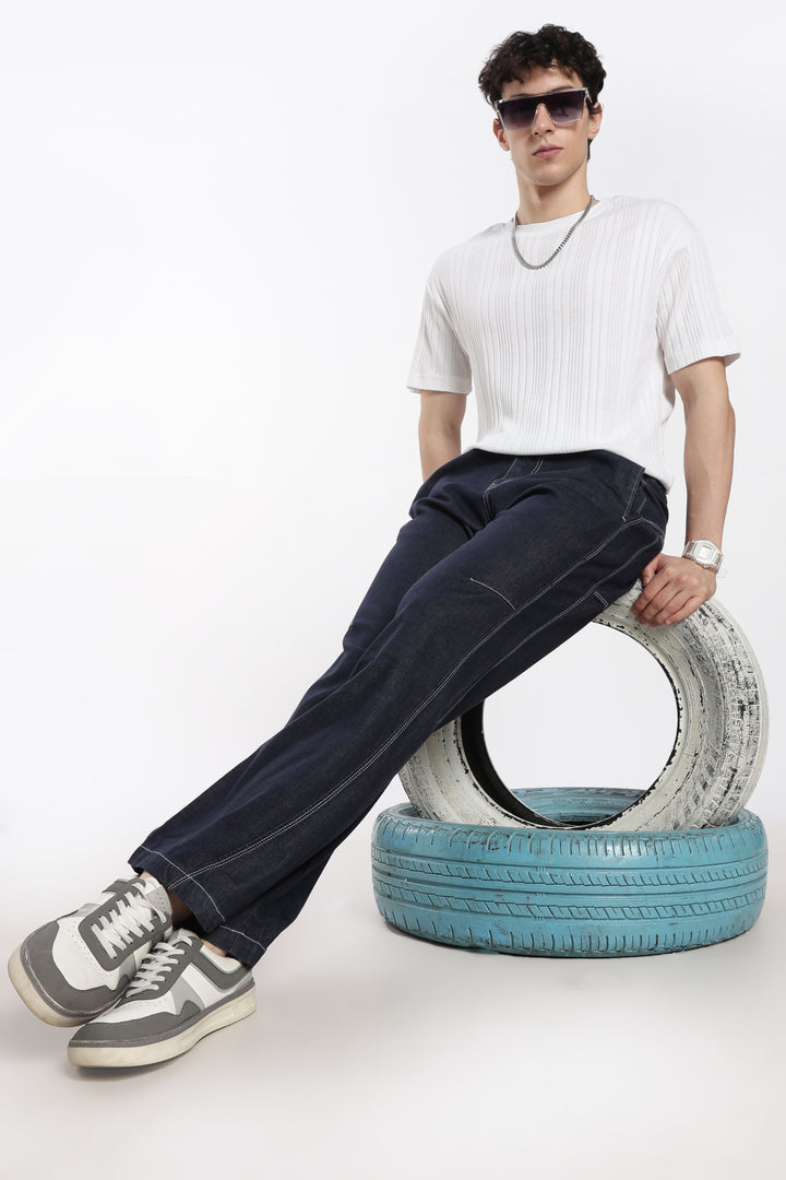 man sitting on a stack of tires against a white background