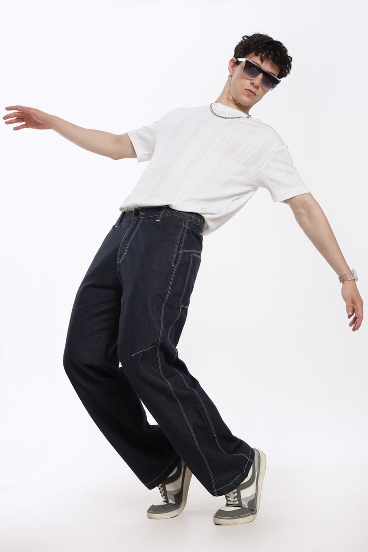 man wearing a white t-shirt, blue denim jogger, and sunglasses on a white background