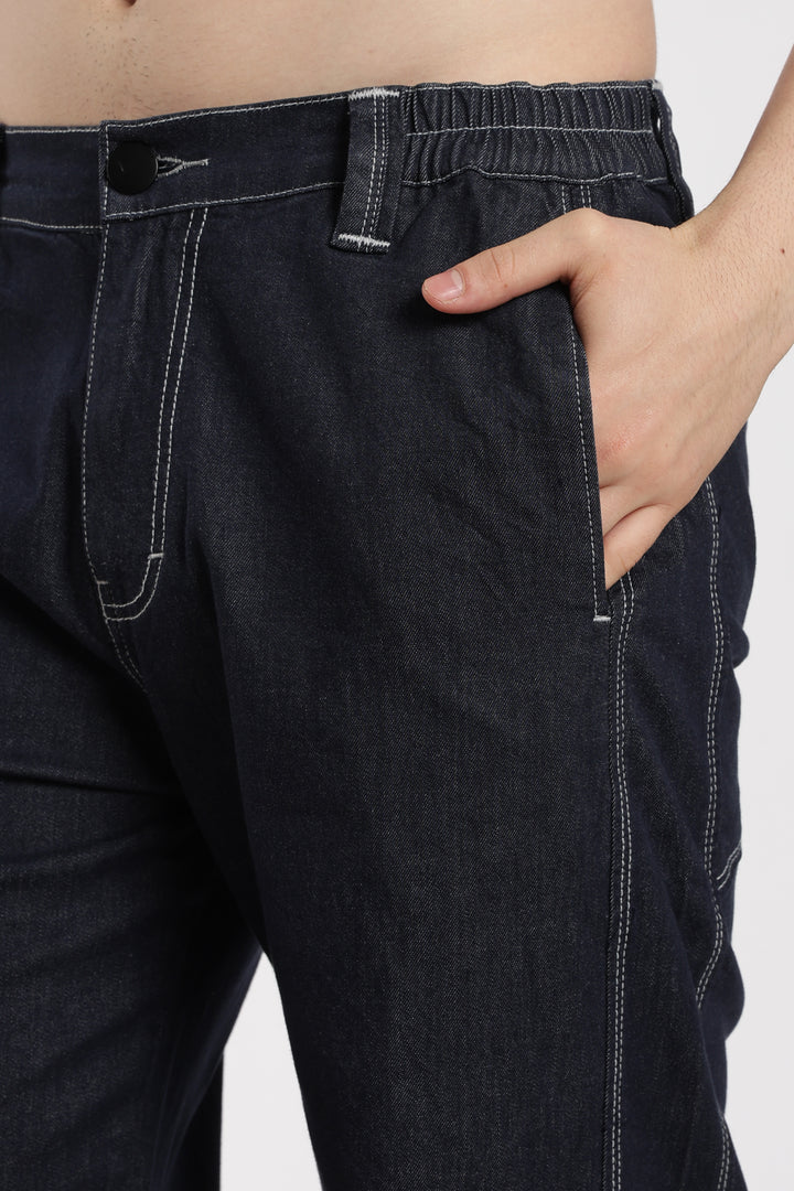 blue denim jogger with a hand in the pocket on a white background