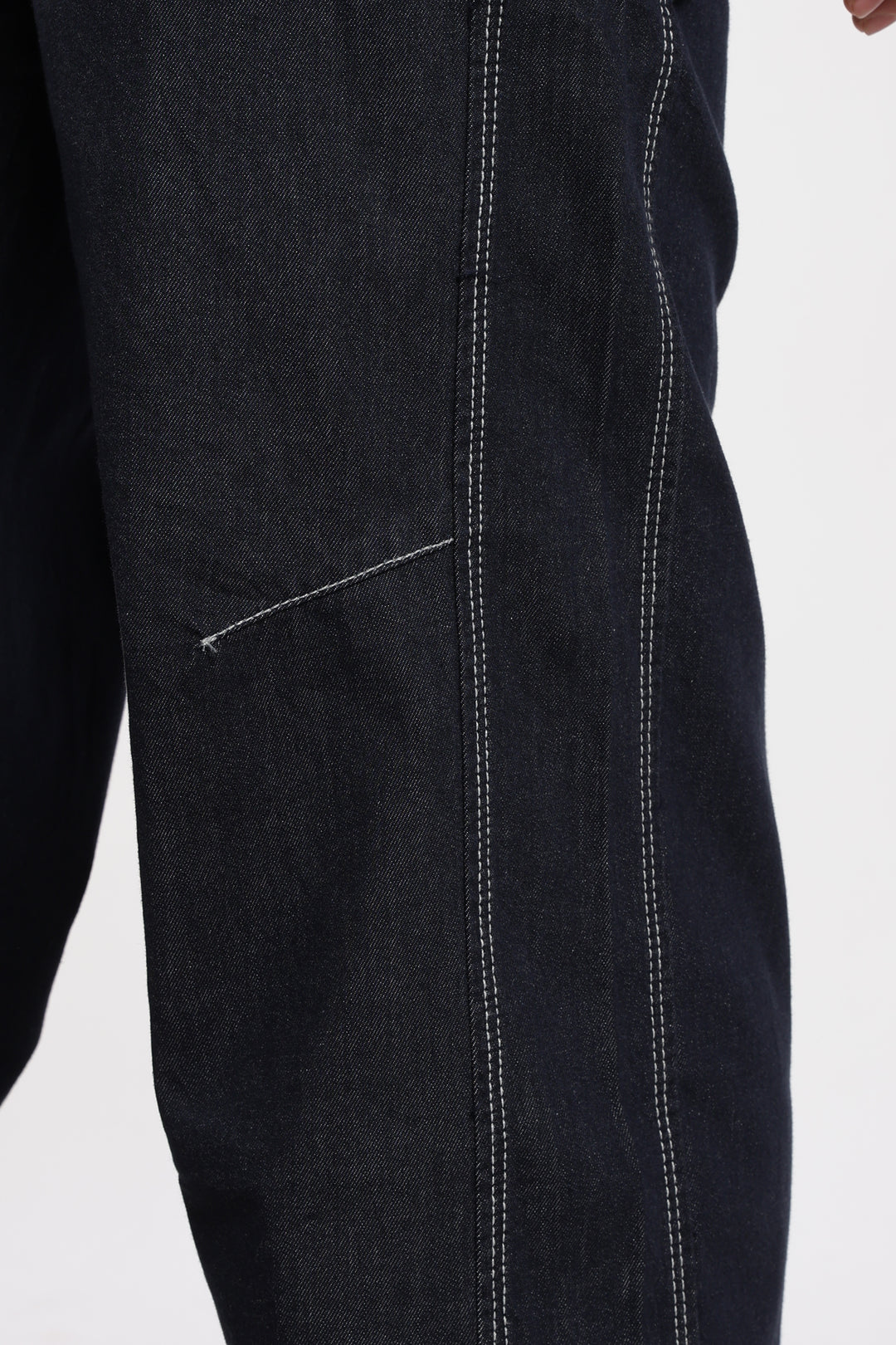 Close-up of blue denim jogger with visible stitching on a white background