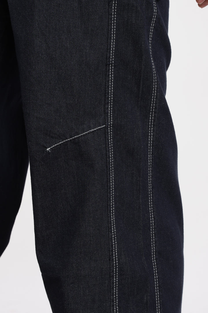 Close-up of blue denim jogger with visible stitching on a white background