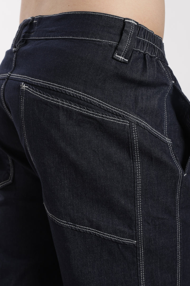 Close-up of blue denim jogger with visible stitching on a white background