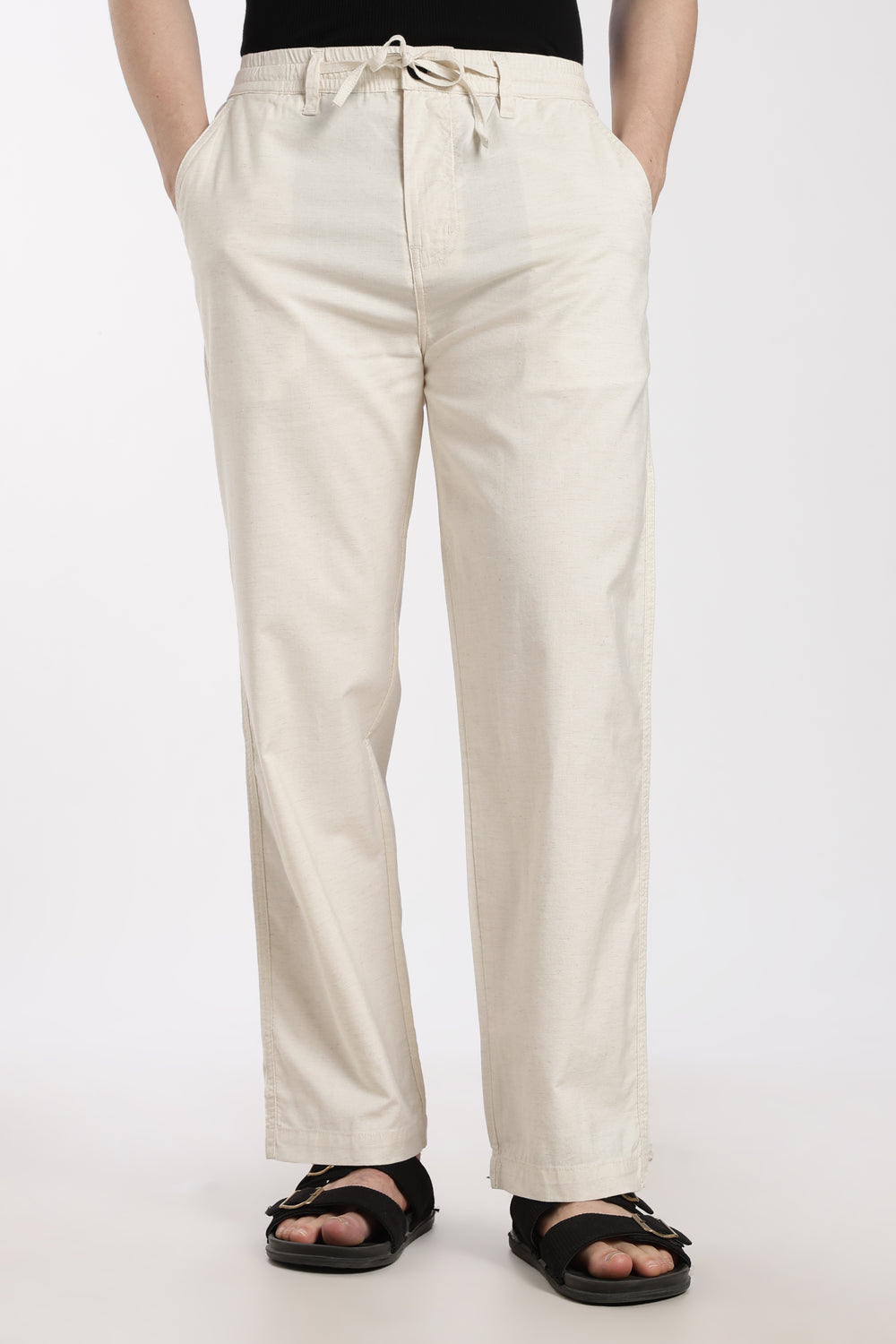 cream linen pants worn by a man on a white background
