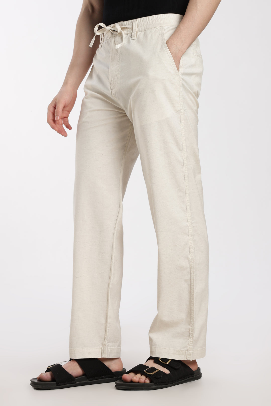 cream linen pants worn by a man on a white background