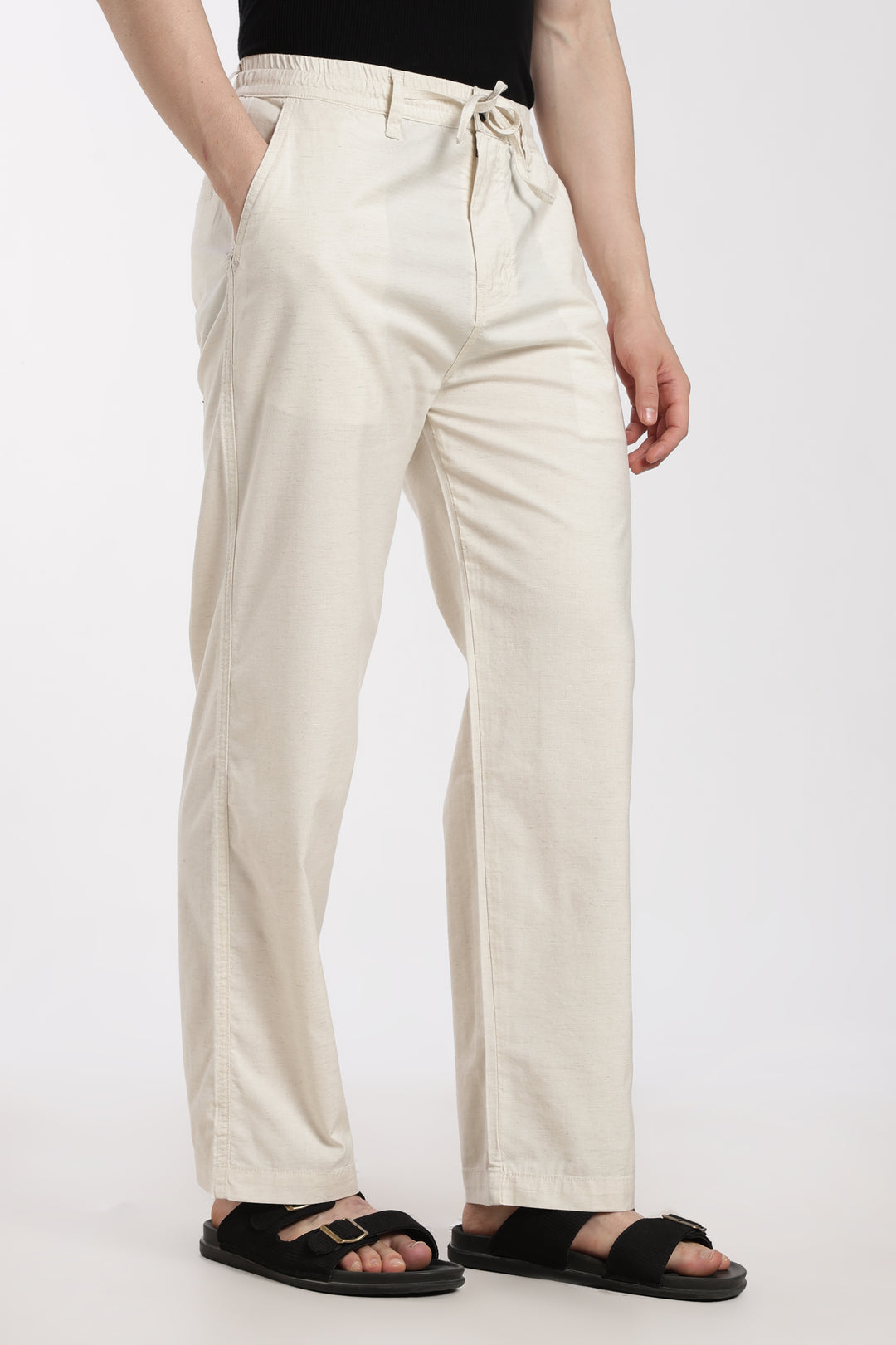 cream linen pants worn by a man on a white background
