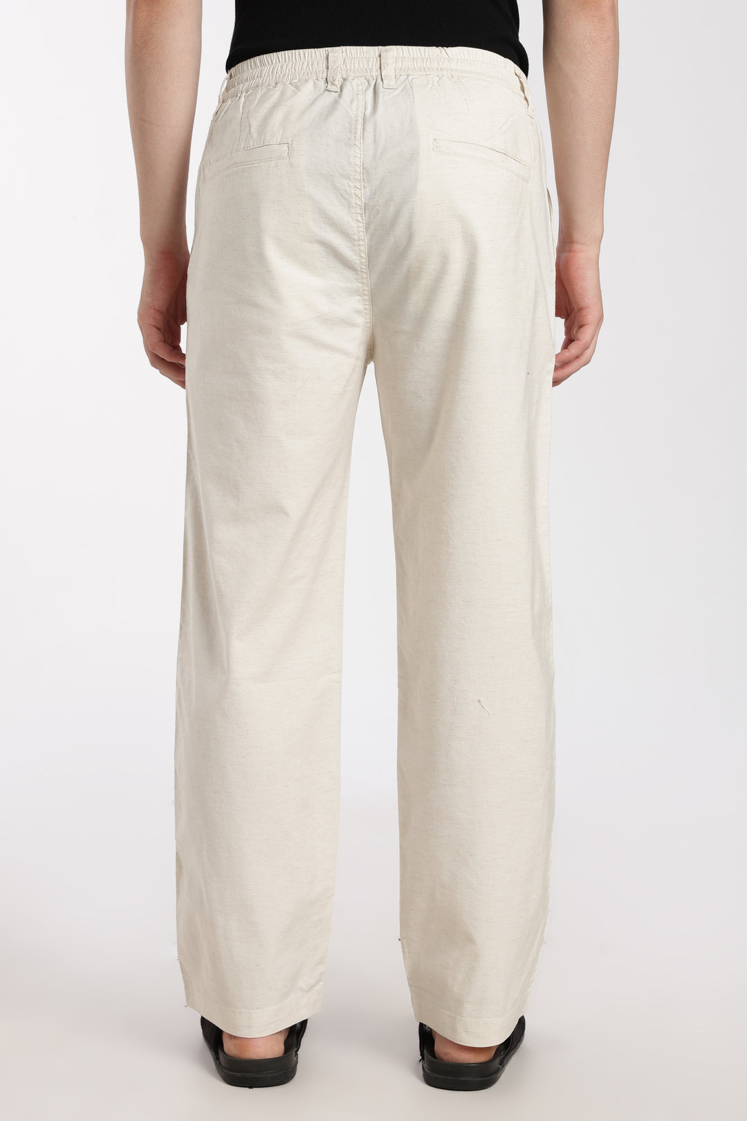 man wearing cream linen pants on a white background