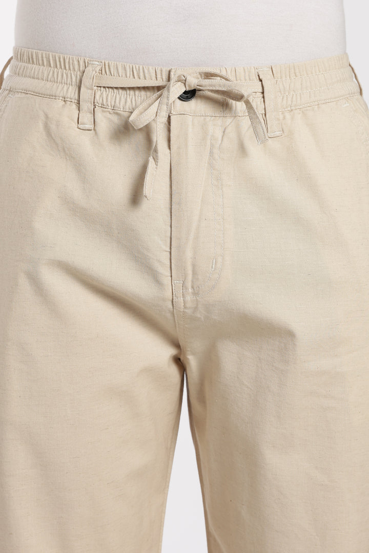 Beige linen pants with a drawstring on a white background