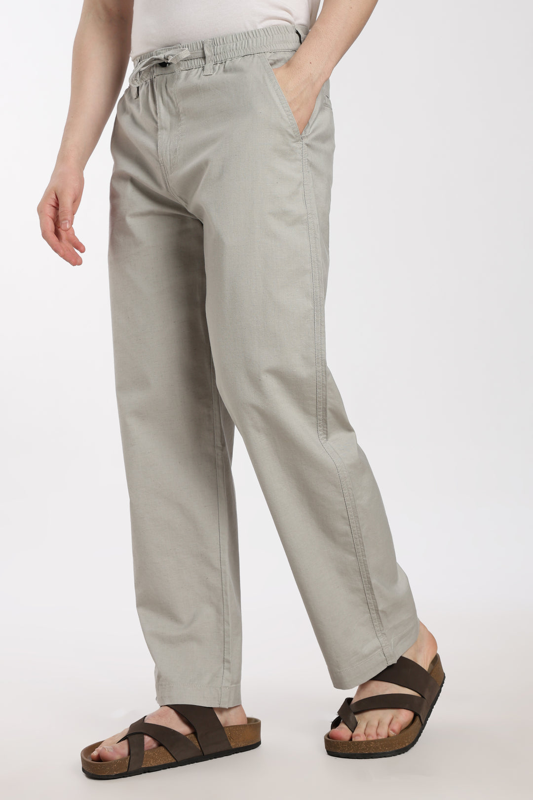 man wearing light gray linen pants on a white background