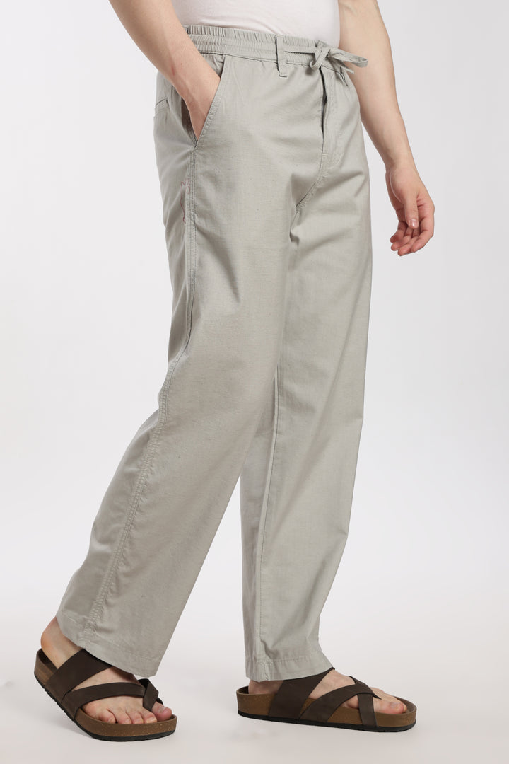 Light gray linen pants worn by a man on a white background