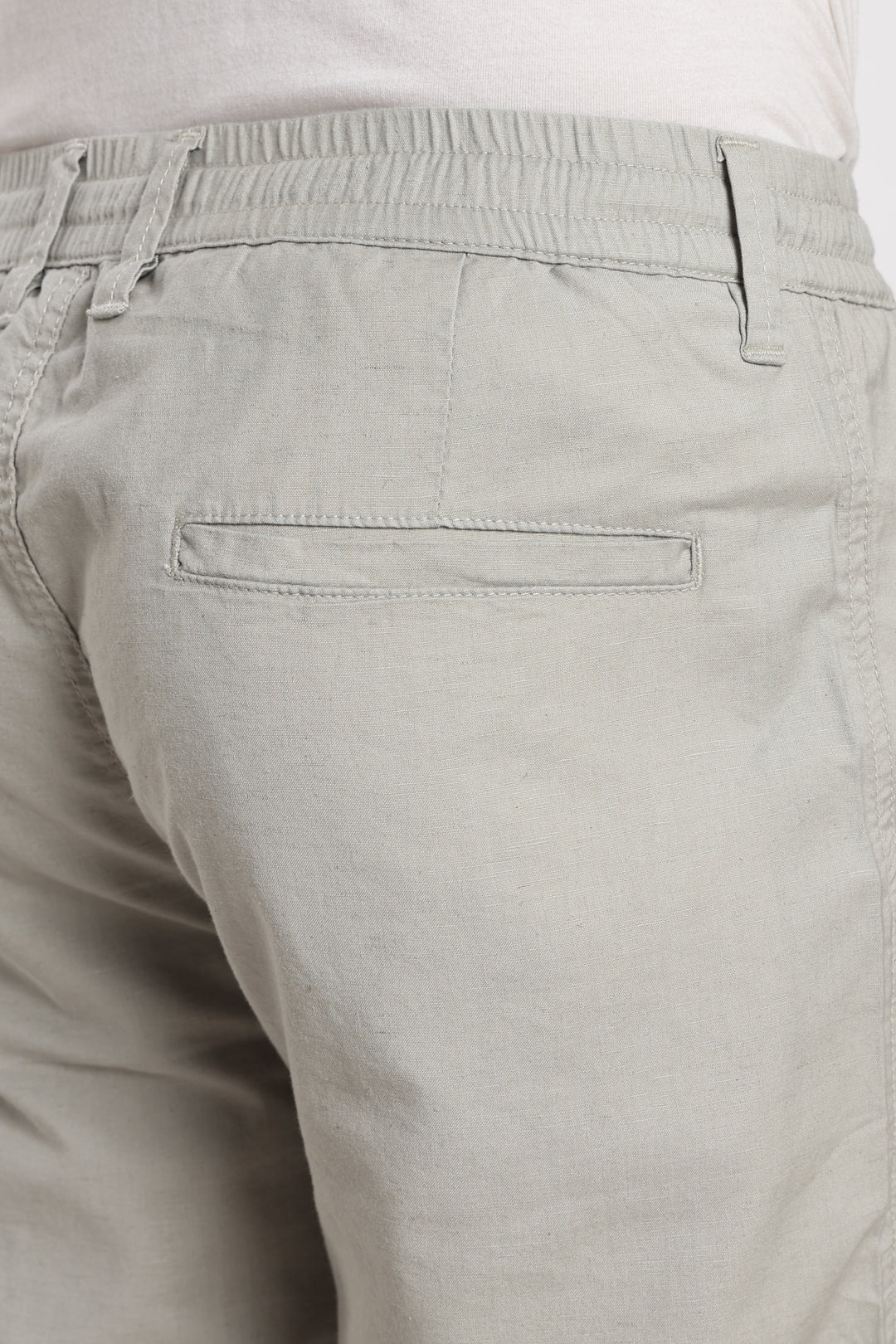 Close-up of beige linen pants on a white background