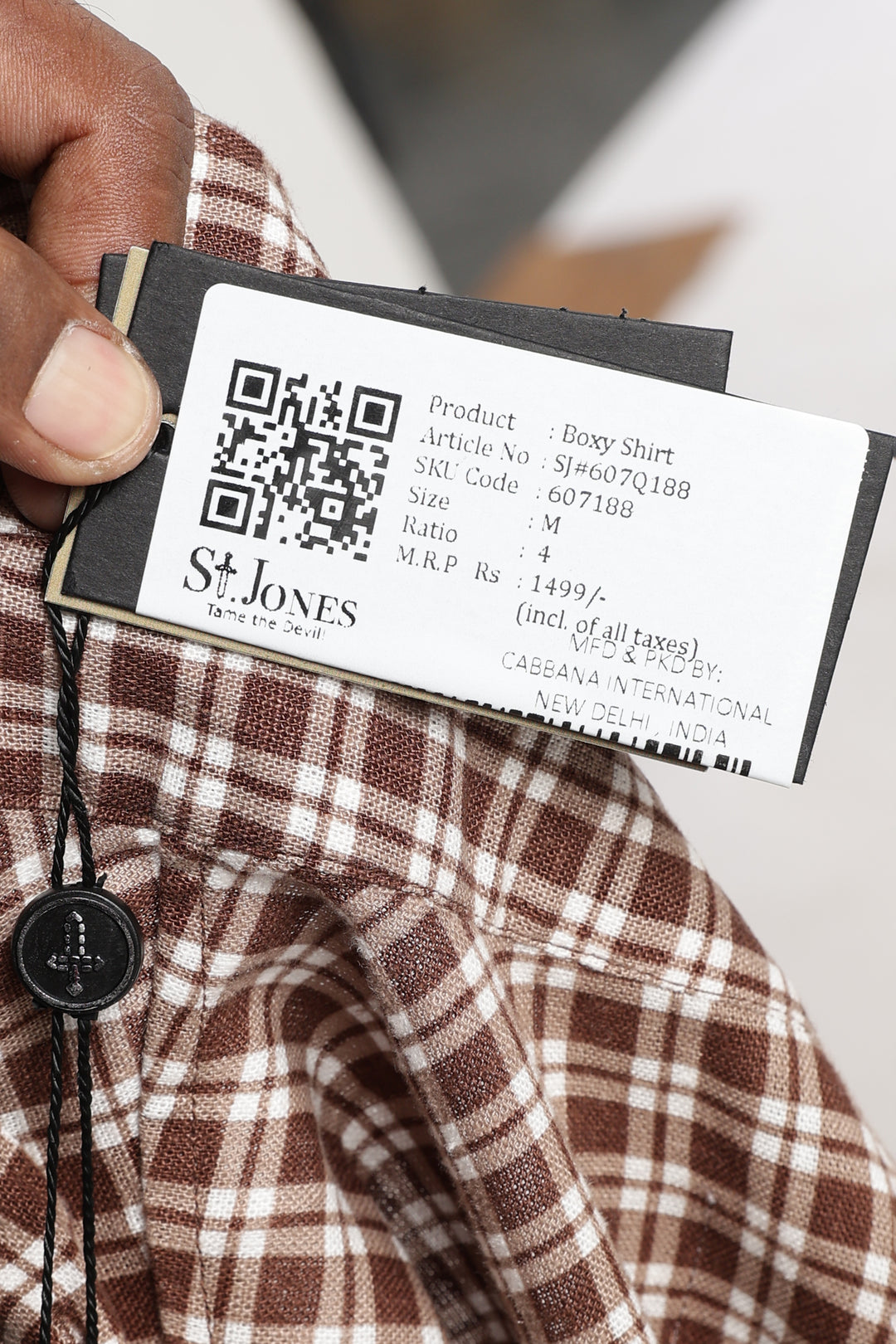 Close-up of a St. Jones shirt tag with a QR code and product details.