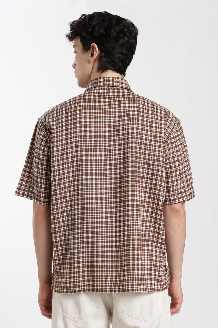 man wearing a brown checkered half sleeve shirt on a white background