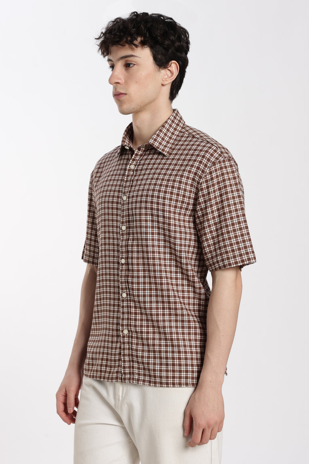 Man wearing a brown checkered half sleeve shirt on a white background