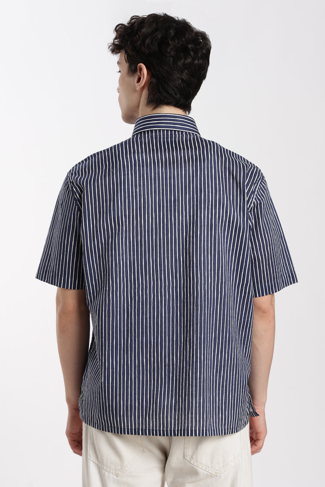 man wearing a blue and white striped half sleeve shirt on a white background 