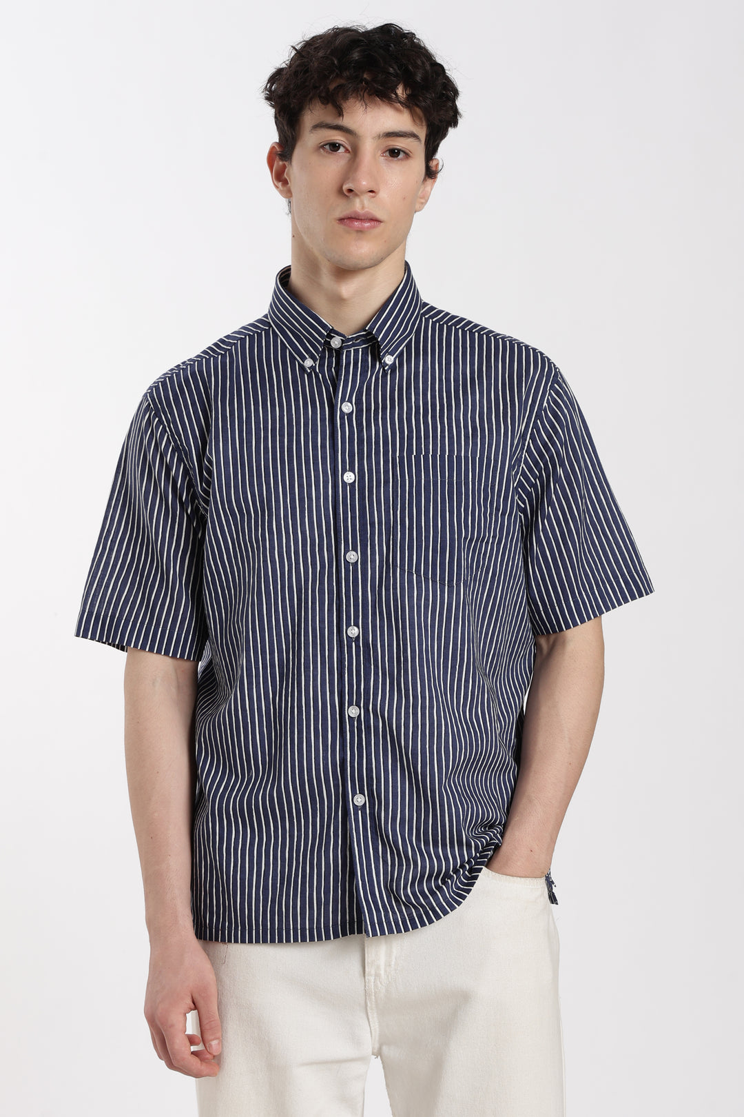 man wearing a navy and white striped half sleeve shirt on a white background