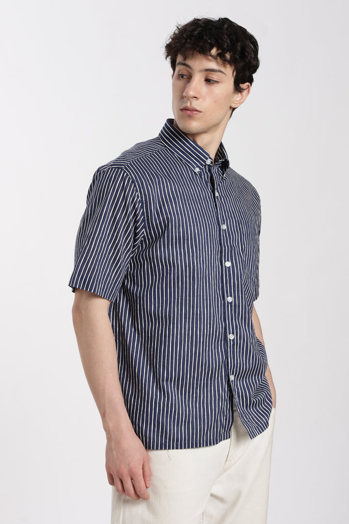 Man wearing a blue striped half sleeve shirt with a cut-out design on a white background