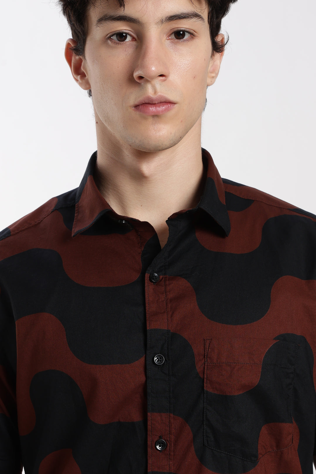 Man wearing a red and black camouflage half sleeve shirt on a white background