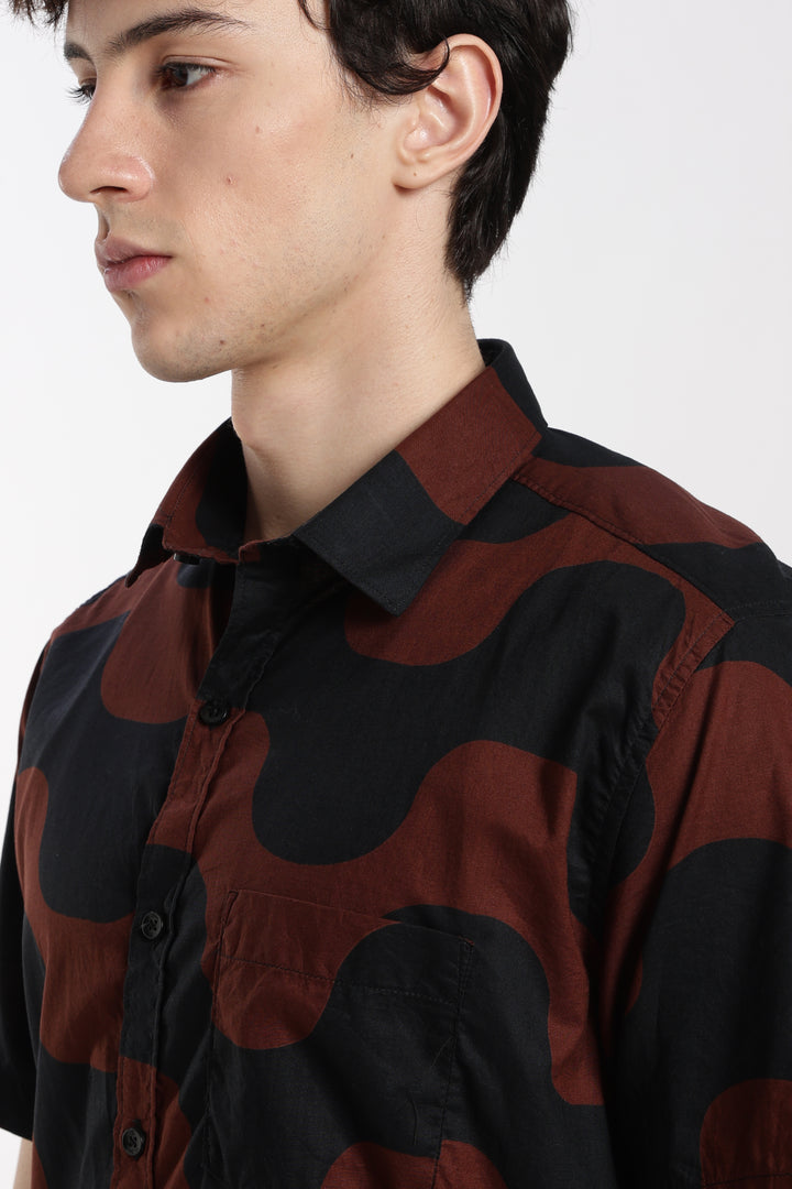 man wearing a black and red patterned half sleeve shirt on a white background