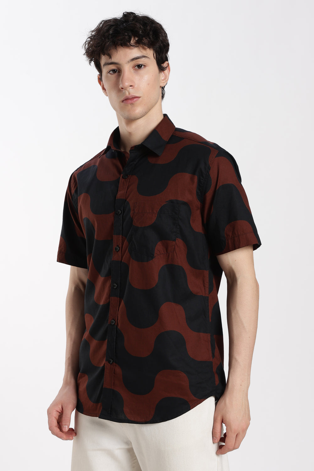 Man wearing a black and red patterned shirt on a white background