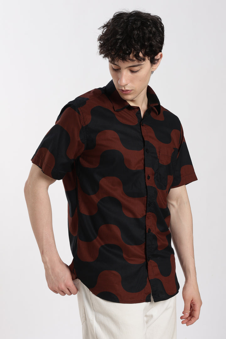 man wearing a black and red patterned shirt on a white background