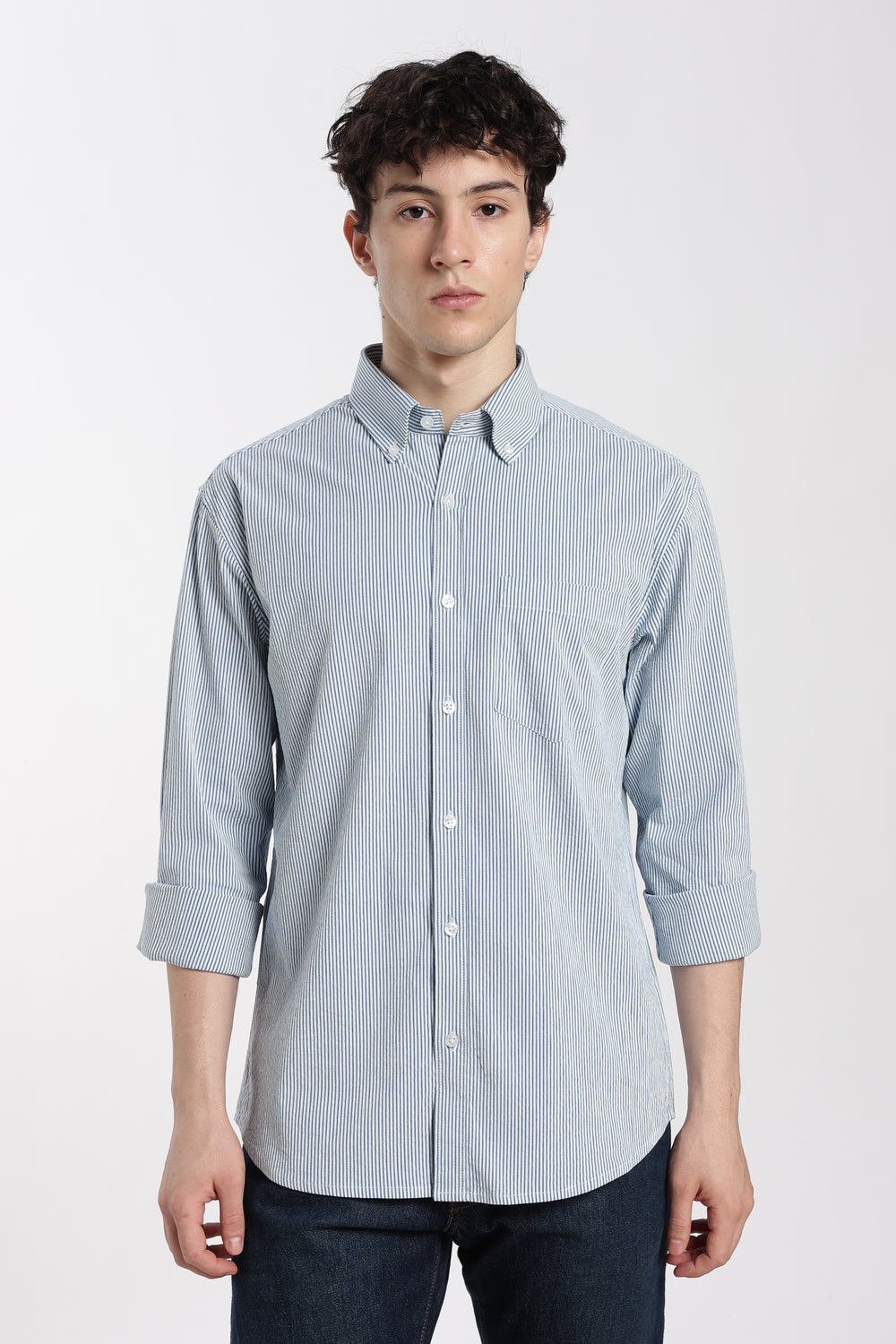 Man wearing a blue striped linen shirt on a white background