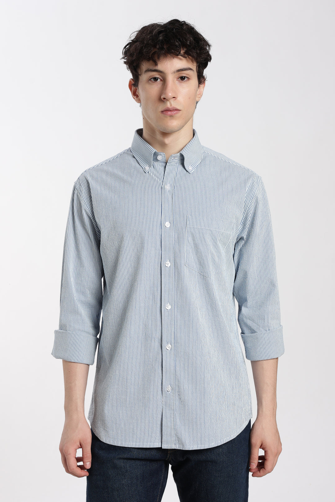 Man wearing a blue striped linen shirt on a white background