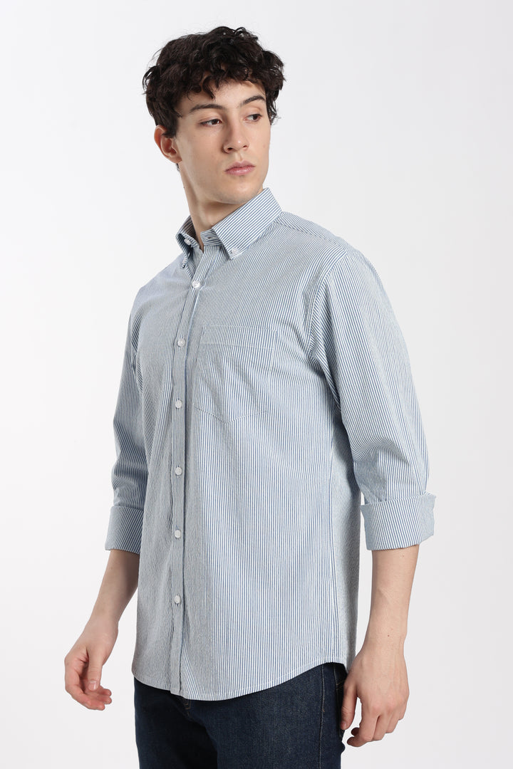 Man wearing a blue checkered linen shirt on a white background
