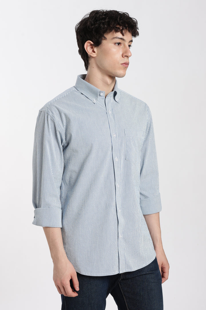 man wearing a blue striped linen shirt on a white background