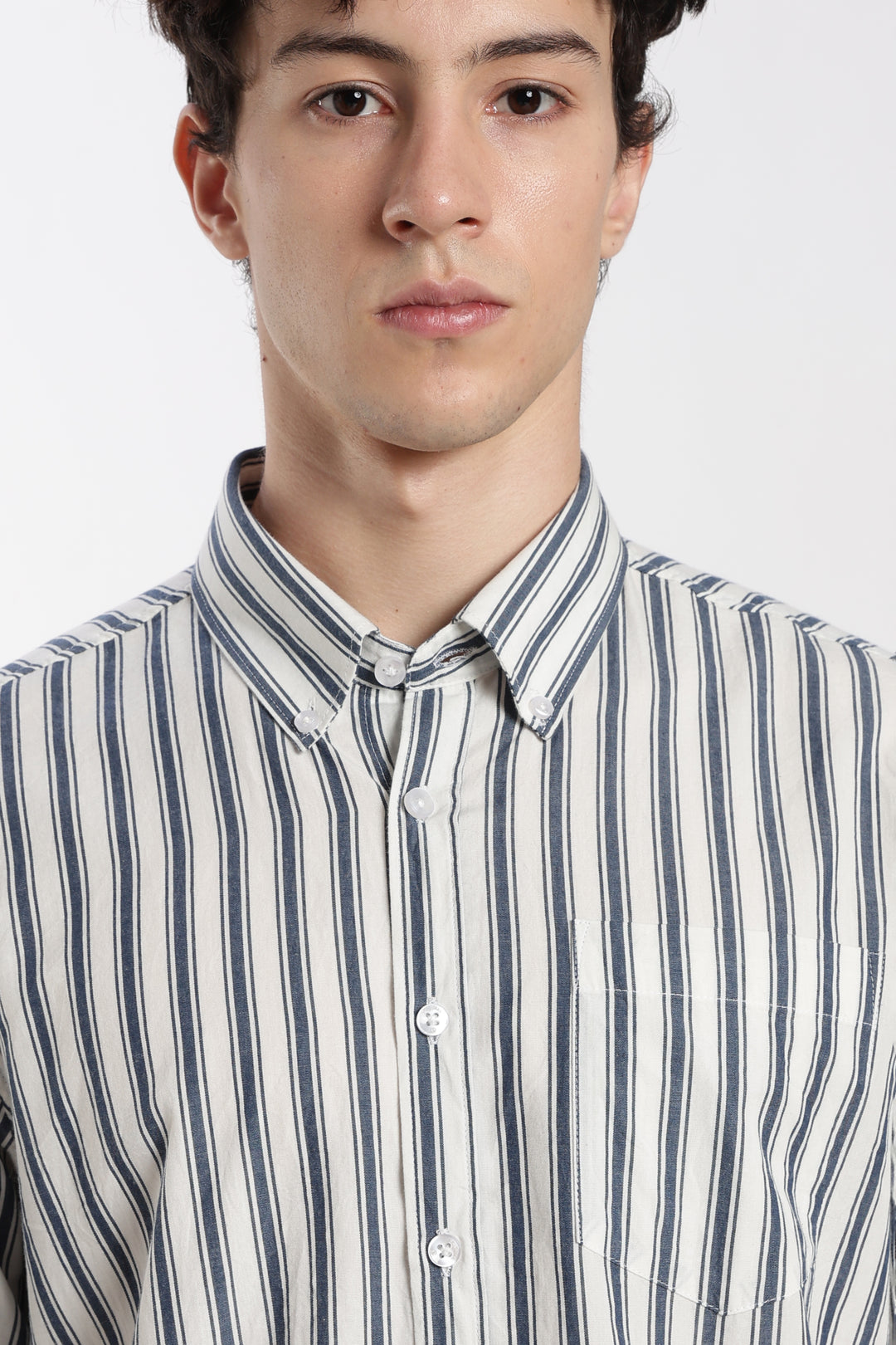Man wearing a striped half sleeve shirt against a white background
