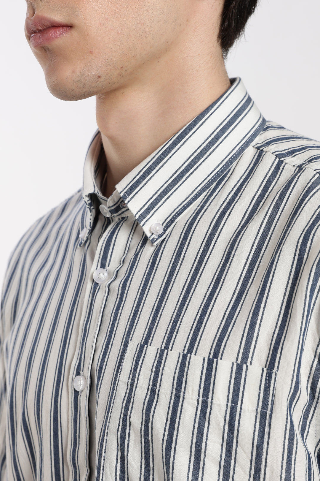 Close-up of a man wearing a striped half sleeve shirt with a white background