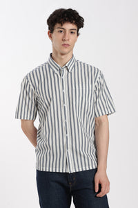Man wearing a striped half sleeve shirt and dark jeans on a white background
