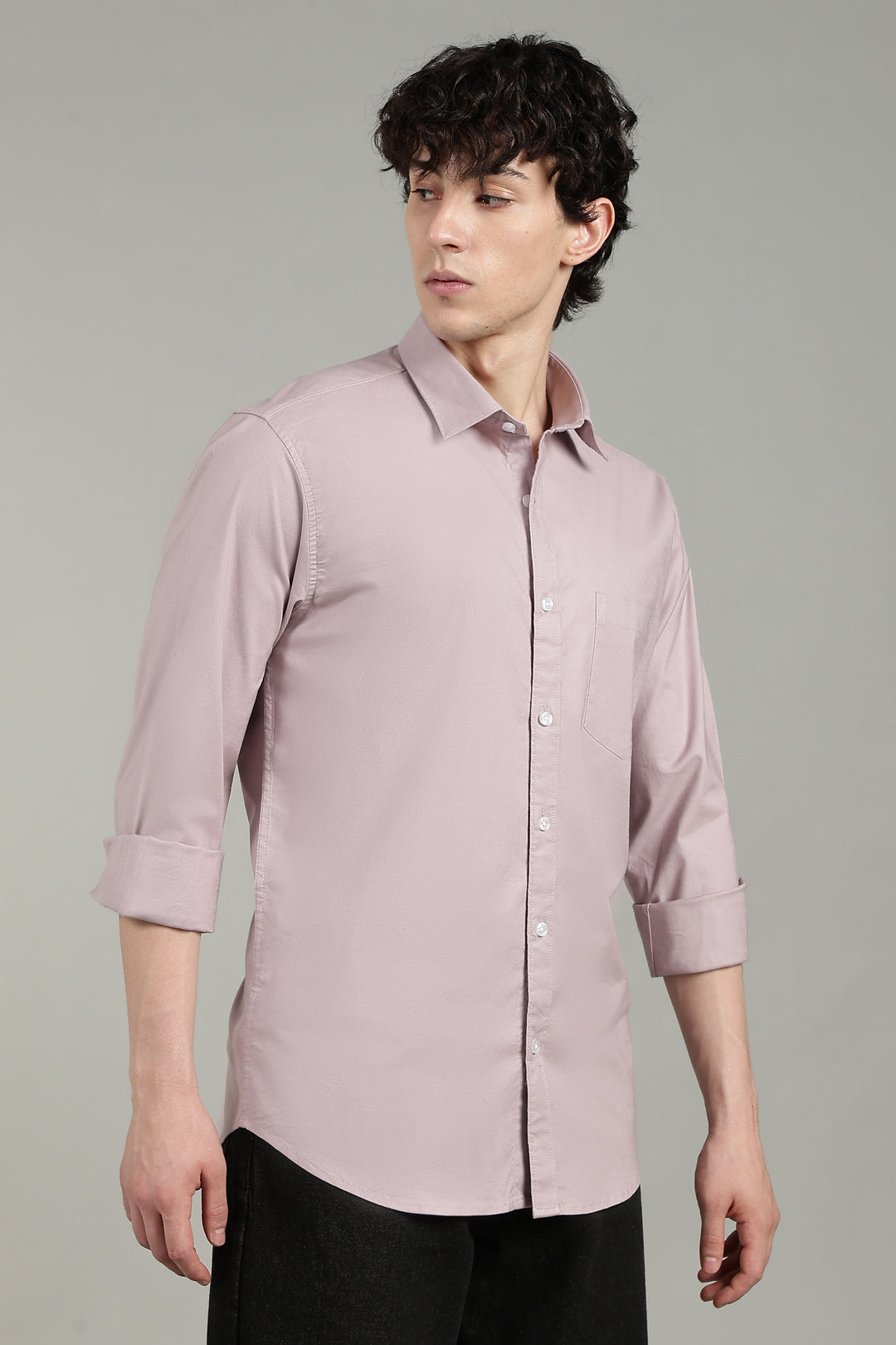 Man wearing a mute pink shirt against a gray background
