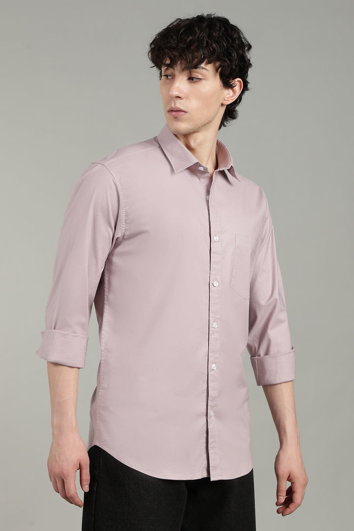 Man wearing a mute pink shirt against a gray background