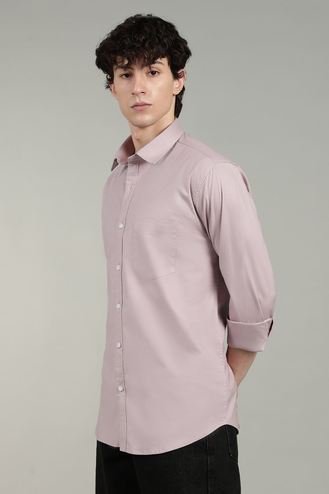 Man wearing a mute pink shirt against a gray background